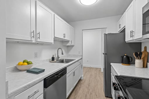 A modern kitchen with white cabinets and stainless steel appliances.
