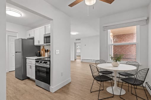 A kitchen with a refrigerator, oven, and microwave.