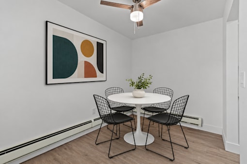 A dining room with a white table and chairs.