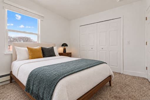 A bedroom with a large bed and a window.