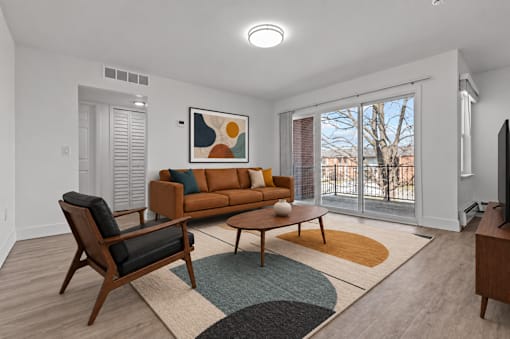 A living room with a brown couch, a chair, and a coffee table.