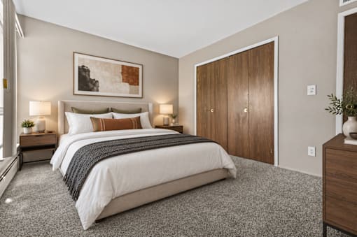 A bedroom with a large bed and a painting above it.