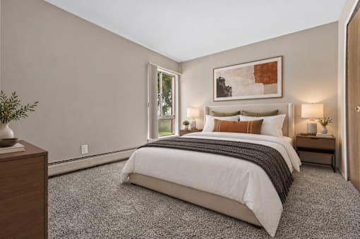 A bedroom with a large bed and a painting on the wall.