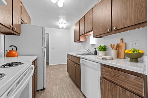 A kitchen with white appliances and wooden cabinets.