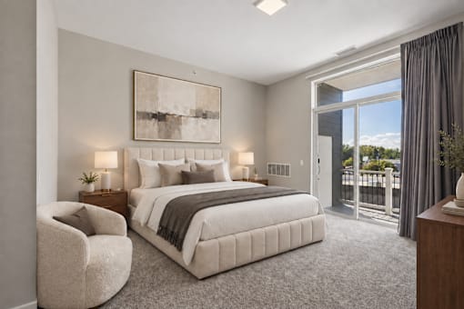 A bedroom with a large bed, a chair, and a painting on the wall.