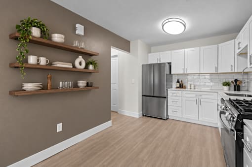 A kitchen with white cabinets and a refrigerator.