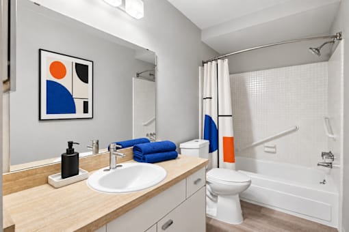 A bathroom with a sink, toilet, and bathtub.