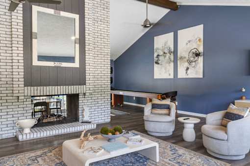 A living room with a fireplace and a painting on the wall.