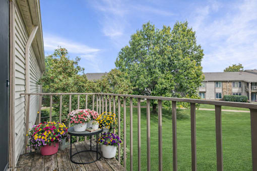 A balcony with a table and chairs with flowers on it.