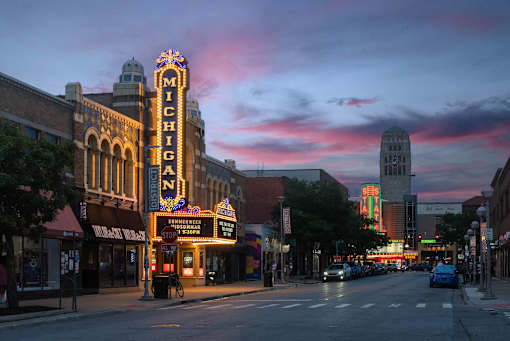 A street view of a city with a large building that has the word "Michigan" on it.