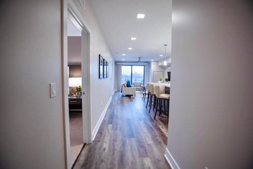 a view of a living room and dining room from the hallway of a house