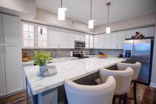 a large kitchen with white cabinets and white counter tops