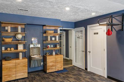 A room with a blue wall and wooden shelves.