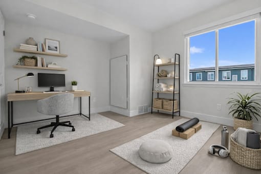 A room with a desk, chair, and shelves with various items.