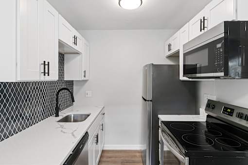 A kitchen with black and white appliances and cabinets at The Park on 13 Apartments - Royal Oak, MI Apartments, Michigan, 48073