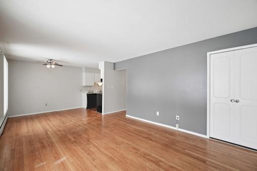 A room with a wooden floor and a ceiling fan.
