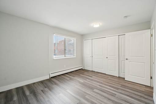 A room with a window and wooden floors.