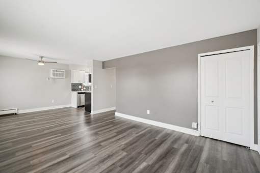 A room with a white door and a wooden floor.