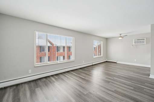 A room with a large window and a ceiling fan.