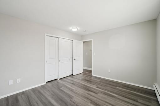 A room with a white door and a grey floor.