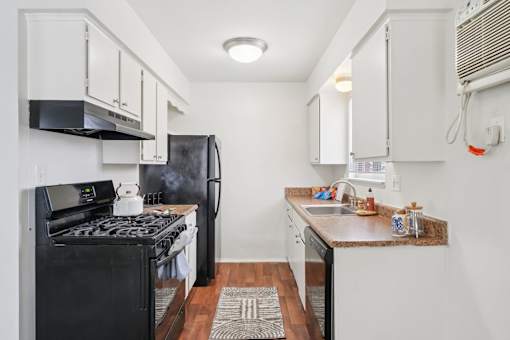 A small kitchen with black appliances and white cabinets.