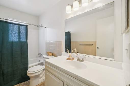 A bathroom with a white sink and a toilet.