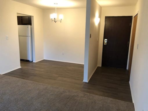 an empty room with a refrigerator and a door