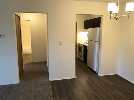 a kitchen with a white refrigerator freezer next to a doorway