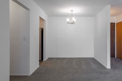 an empty room with a chandelier and a door