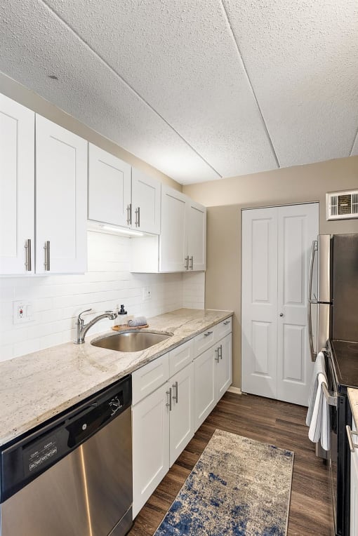 a kitchen with stainless steel appliances and white cabinets at Troy Place Apartments - Troy, MI, Troy, Michigan