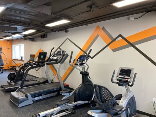 a workout room with treadmills and other exercise equipment in a gym at Troy Place Apartments - Troy, MI, Troy, Michigan