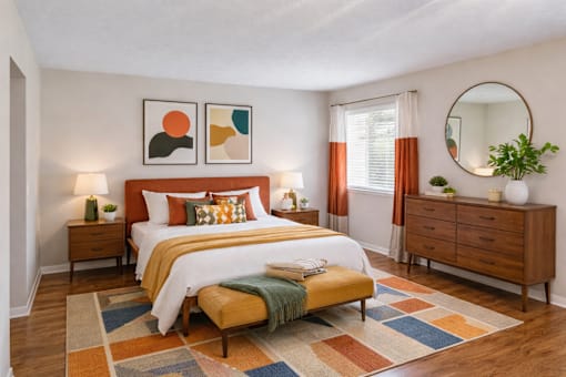 A bedroom with a bed, nightstands, and a dresser.