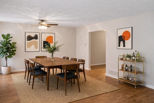 A dining room with a wooden table and chairs.