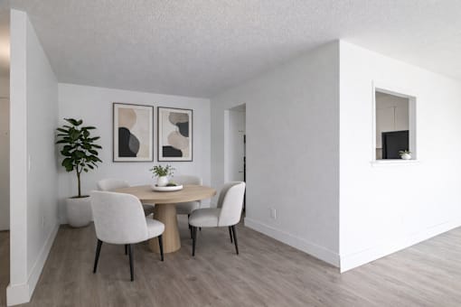 A dining room with a table and chairs.