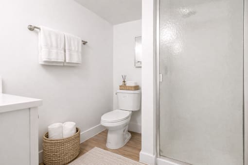 A white toilet sits in a bathroom next to a towel rack.