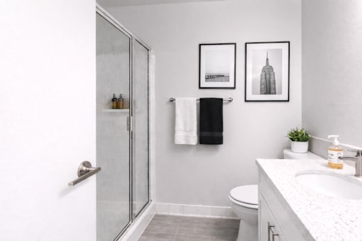 A bathroom with a toilet, sink, and shower.