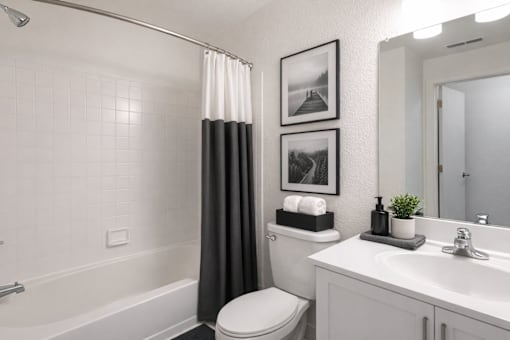 A white bathroom with a toilet, sink, and shower.