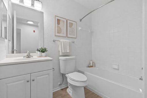 A white bathroom with a toilet, sink, and bathtub.