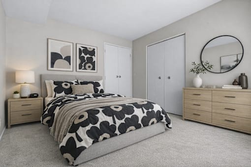 A bedroom with a bed, nightstands, and a mirror.