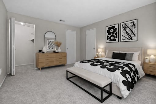 A bedroom with a bed, nightstands, and a dresser.