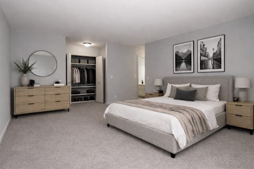 A bedroom with a large bed, a dresser, and a mirror.