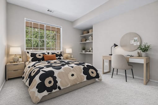 A bedroom with a large bed, a desk with a chair, and a window with a view of trees.
