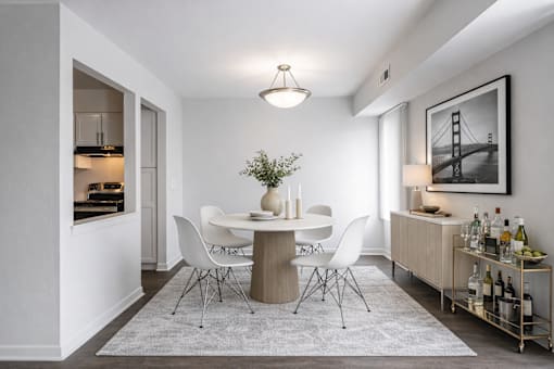 A dining room with a white table and chairs.