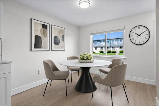 A dining room with a table and chairs.