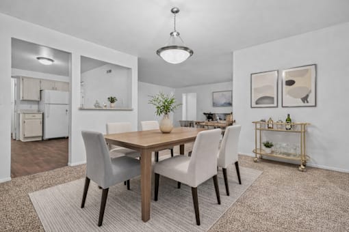 A dining room with a table and chairs.