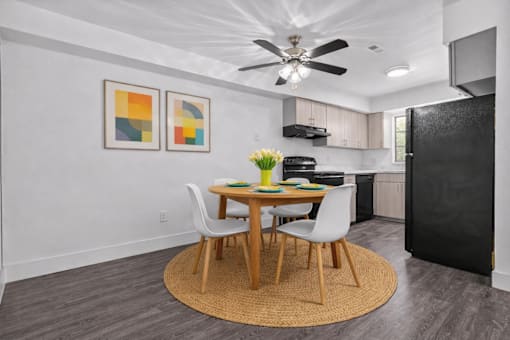 A kitchen with a table and chairs in the middle of the room.