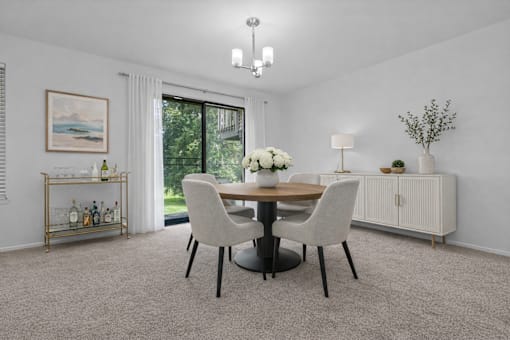 A dining room with a round table and chairs.