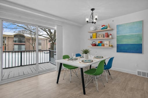 A dining room with a white table and green chairs.