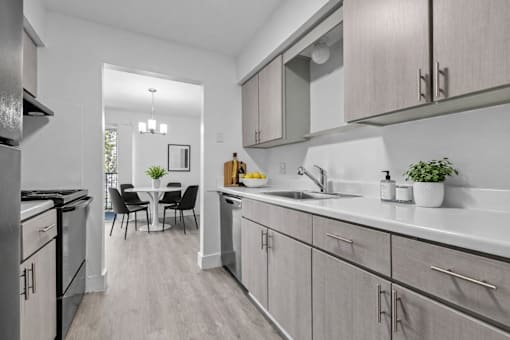 A modern kitchen with a dining table and chairs in the background.