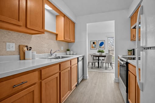 A kitchen with wooden cabinets and a white refrigerator.